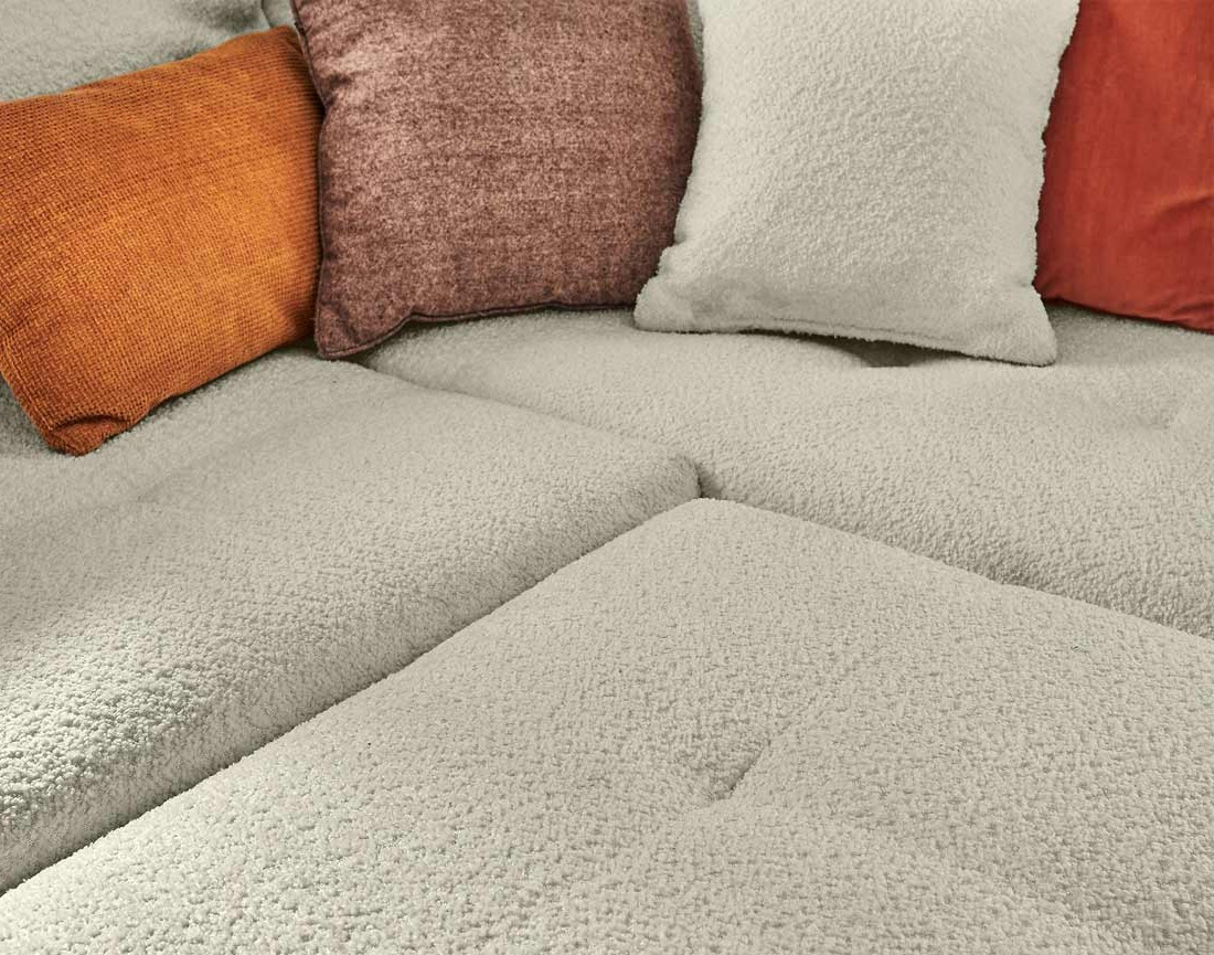 Canapé panoramique d'angle gauche 7 places avec pouf d'appoint en tissu bouclette Rune